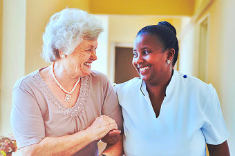 caregiver and a senior woman smiling to each other