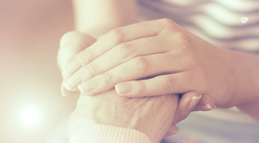 caregiver holding her patient hand