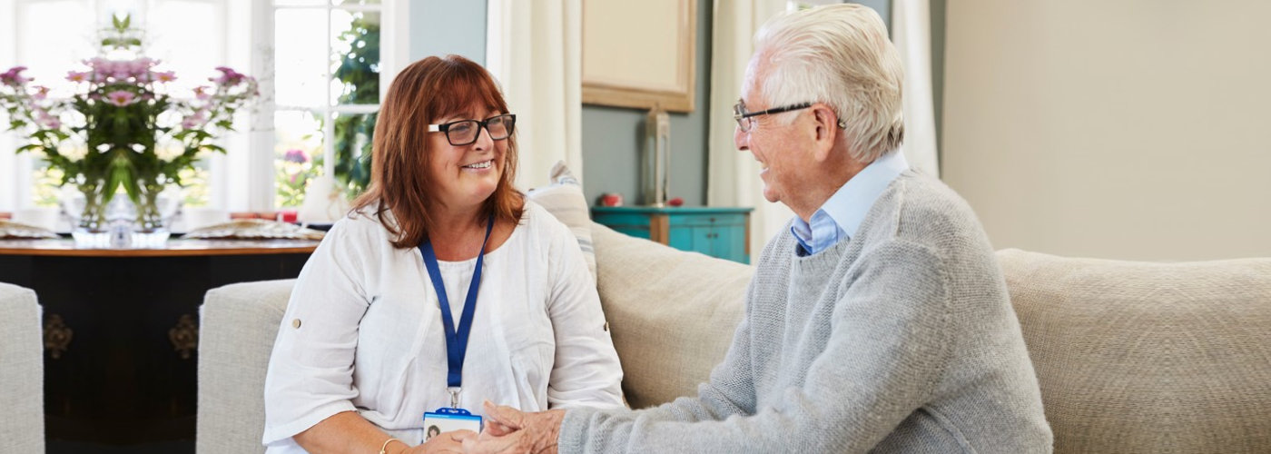 caregiver and a senior man conversing